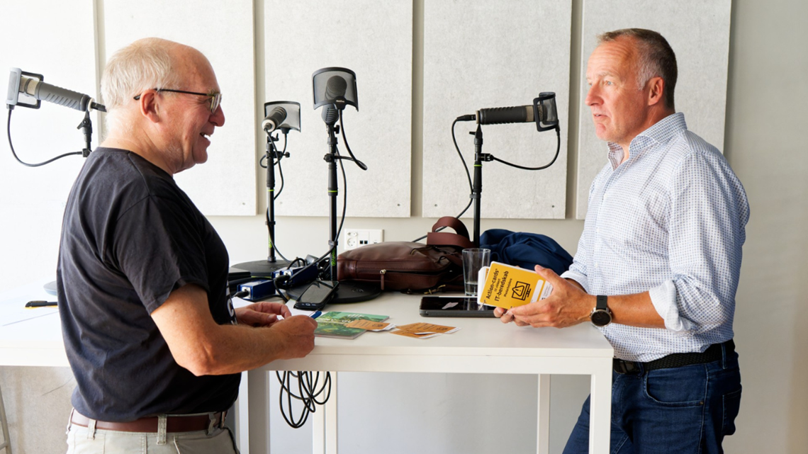 Jens Henning Ravnsmed interviewer Claus Due i studiet med mikrofoner, Claus due har action card i hånden 